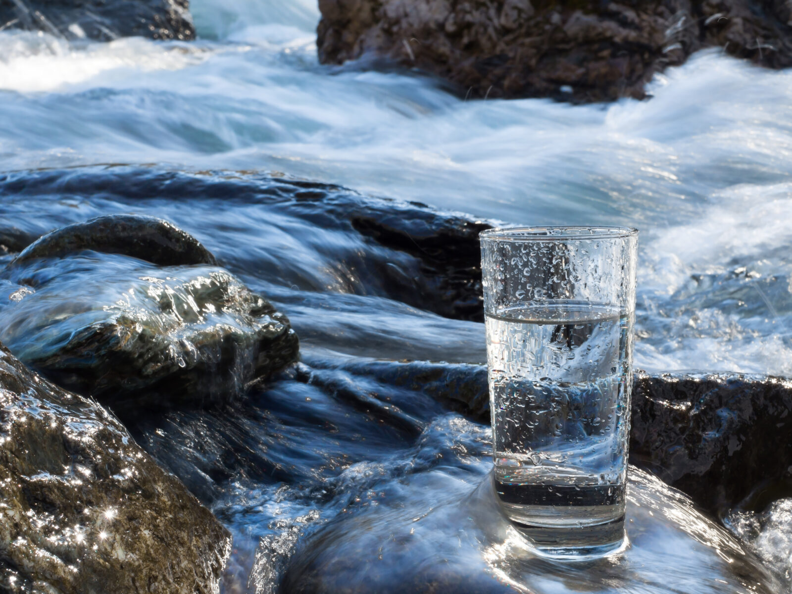 A picture of a drinking glass in a stream for a post on Source Water Protection Week.
